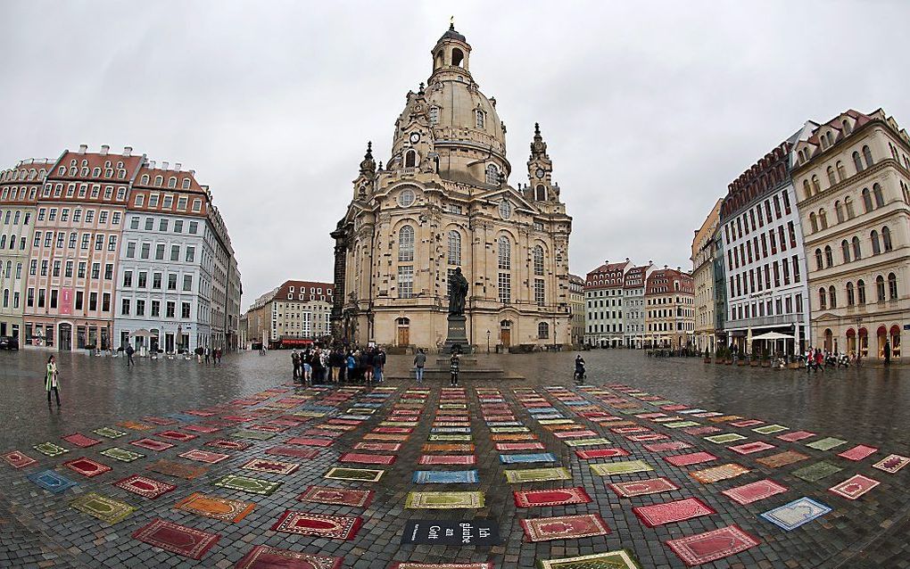 Islamitische gebedskleedjes voor de Frauenkirche in het Duitse Dresden. De Duitse artiest Kurt Fleckenstein plaatste de kleedjes voorafgaande aan de anti-islambetoging van Pegida. De kunstenaar neemt stelling tegen Pegida en pleit voor meer tolerantie. be