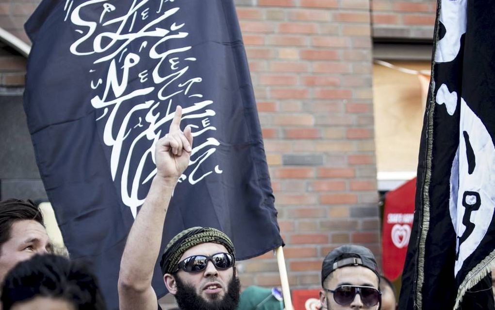 Strijders voor IS doen zich religieus voor, maar zijn uiteindelijk meer geïnteresseerd in hun wapens. Foto: aanhangers van IS tijdens een demonstratie in de Haagse Schilderswijk.  beeld ANP