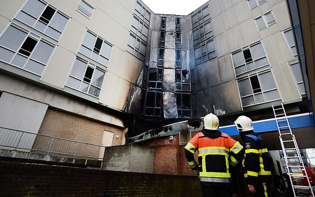 Brandweerlieden bij de uitgebrande cafetaria in de Otto C. Huismanstraat in Nijmegen. Beeld ANP