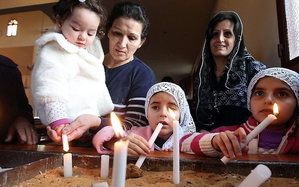 Syrische christenen, gevlucht naar Libanon, bidden tijdens een dienst voor de ontvoerde christenen. Beeld AFP