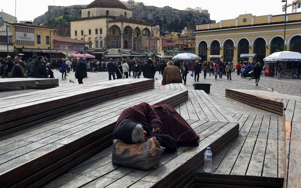 Een vrouw die dakloos is, ligt te slapen in Athene. beeld EPA