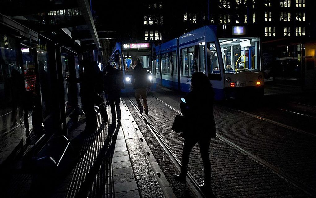 Mensen stappen in het donker op de tram. beeld ANP