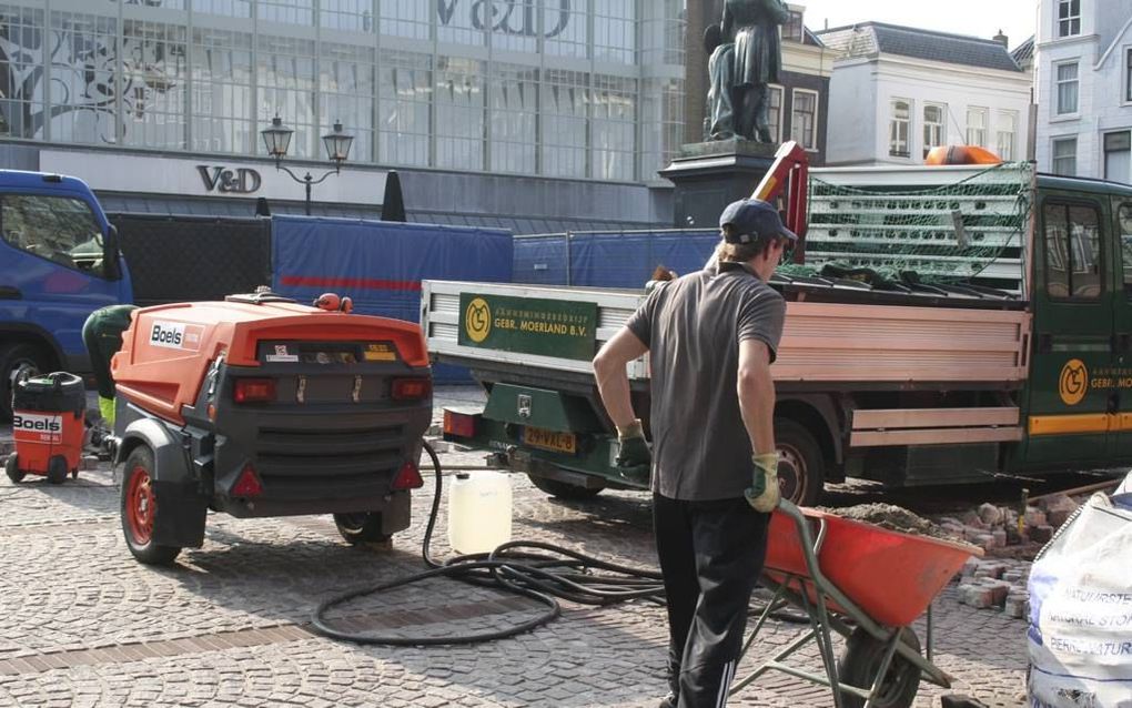 Mannen aan het werk achter het scherm op het Scheffersplein in Dordrecht.  beeld André Bijl