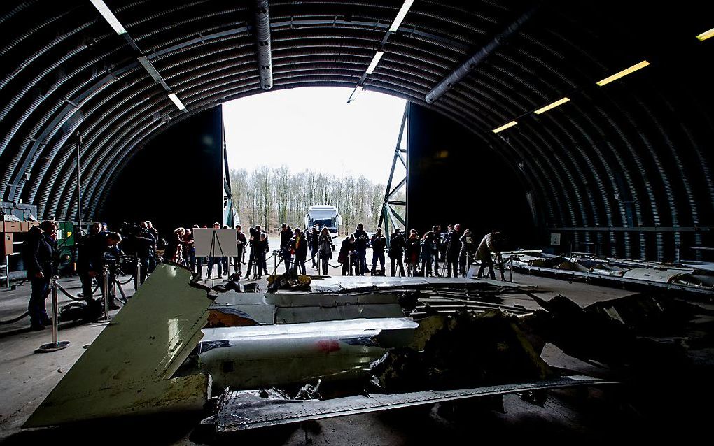 Pers neemt een kijkje bij de wrakstukken van het toestel van de ramp met vlucht MH17 die liggen op vliegbasis Gilze-Rijen. Beeld ANP