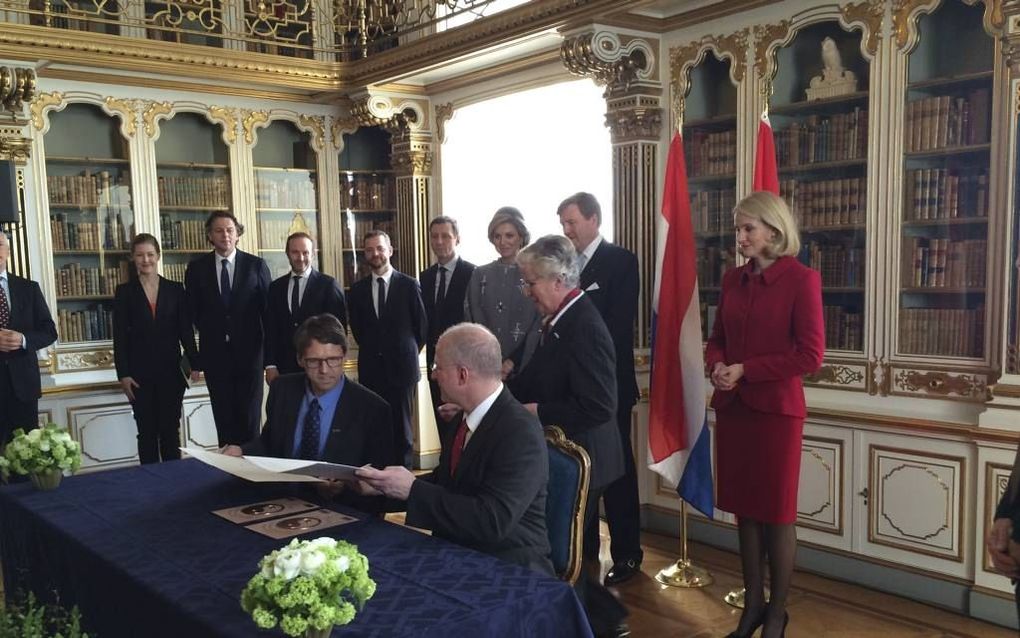 Dirk Jan van der Berg (l.), voorzitter van het college van bestuur van TU Delft en Charles Marcus (r.), directeur van QDev ondertekenen in paleis Christiansborg in Kopenhagen een samenwerkingsovereenkomst. Koning Willem-Alexander, koningin Máxima en de De