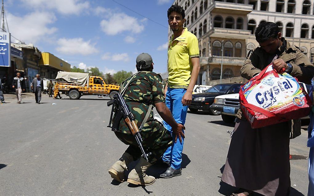 Een Houthi-rebel fouilleert een voorbijganger in Sana. beeld EPA