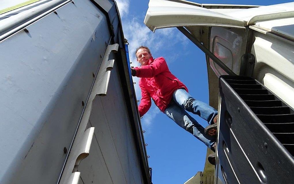 Vrachtwagenchauffeur Ronald Kuipers tussen zijn cabine en de oplegger. Beeld RD