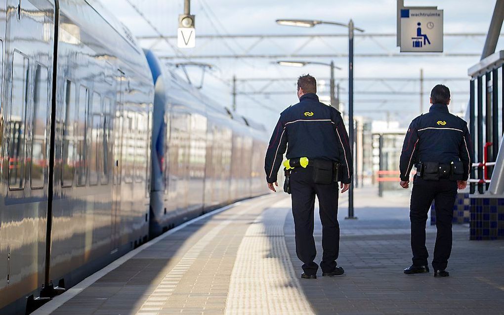 NS-beveiligingsbeambten wachten op de komst van een trein. beeld ANP