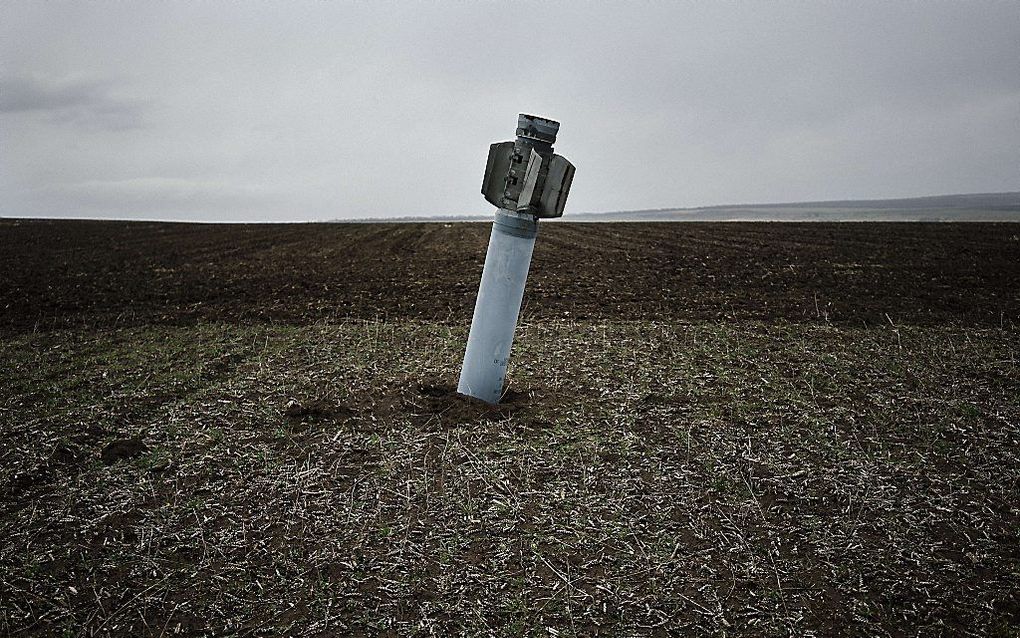 Een niet-ontplofte raket steekt uit de grond op een akker bij het Oost-Oekraïense dorp Dmitrivka, maandag. beeld AFP