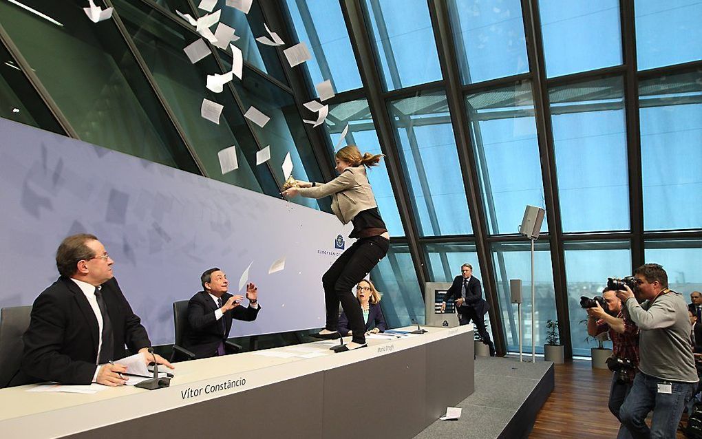 Een onbekende vrouw belaagt Mario Draghi van de Europese Centrale Bank (ECB). beeld AFP