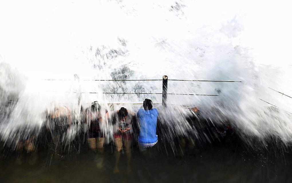 Mensen trotseren enorme golven op het strand van San Blas, in La Libertad, 34 km ten zuiden van San Salvador. beeld AFP