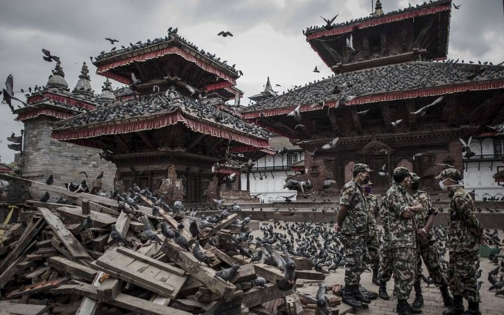 KATHMANDU. Militairen staan bij puinhopen in de hoofdstad Kathmandu. Zeker 5000 mensen kwamen om bij de aardbeving in Nepal.  beeld AFP