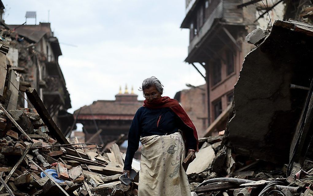 BHAKTAPUR. Een vrouw zoekt in de Nepalese stad Bhaktapur naar bezittingen in het puin. beeld AFP