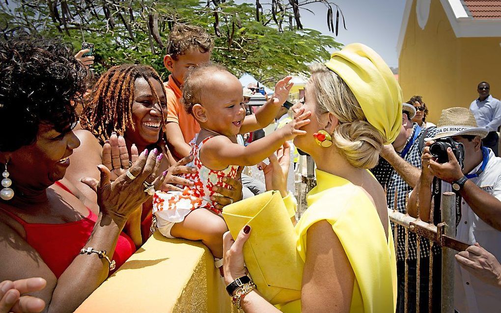 Koningin Máxima wordt begroet en geknuffeld door een baby tijdens haar bezoek aan  Bonaire. Het koningspaar woont festiviteiten bij van het Caribische eiland ter gelegenheid van Día di Ricon. beeld ANP