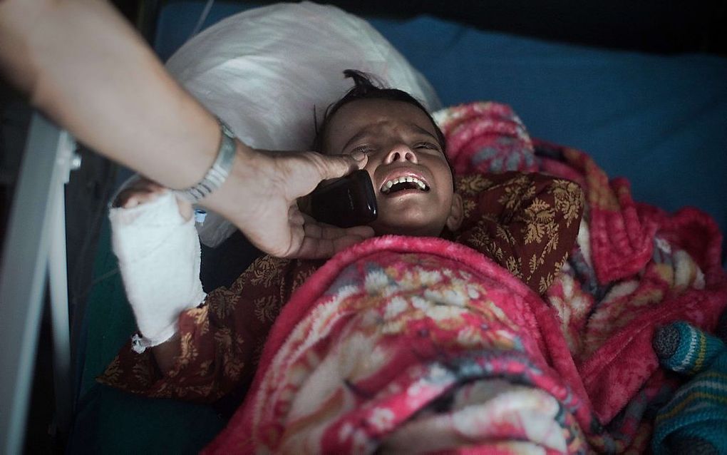 De 5-jarige Sabita in een ziekenhuis in Kathmandu. Via de mobiele telefoon spreekt het Nepalese meisje voor het eerst sinds de aardbeving op 25 april weer met haar moeder. beeld AFP