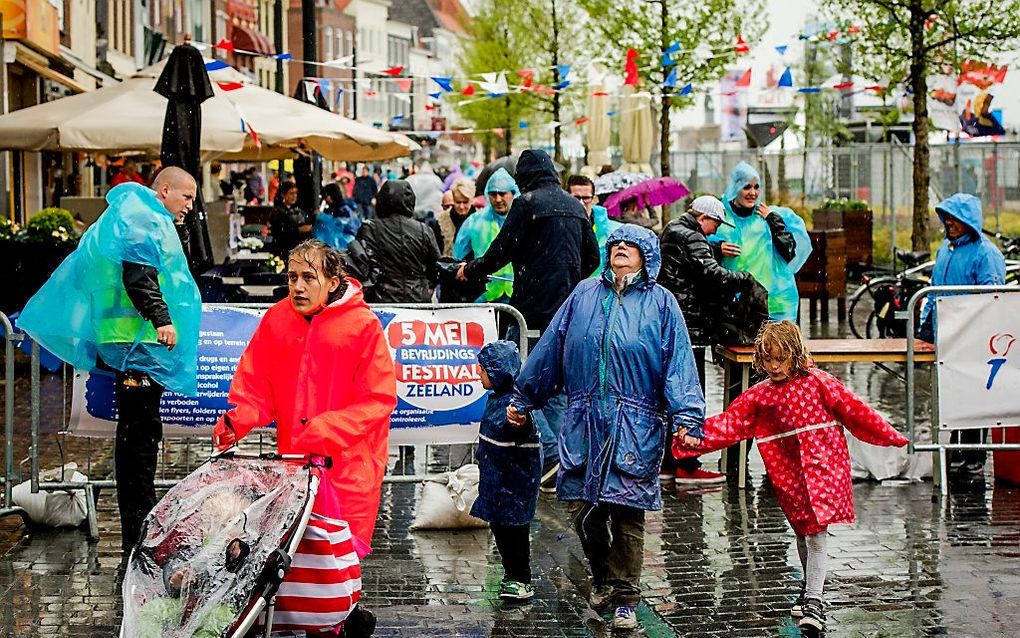 Bezoekers in regenponcho's tijdens de start van Bevrijdingsdag in Vlissingen. beeld ANP