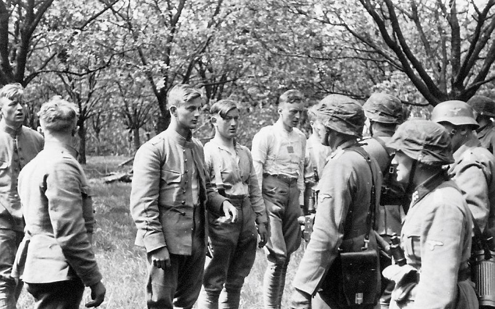 SS'ers ondervragen Nederlandse soldaten in de voorposten van de Grebbelinie. beeld NIMH