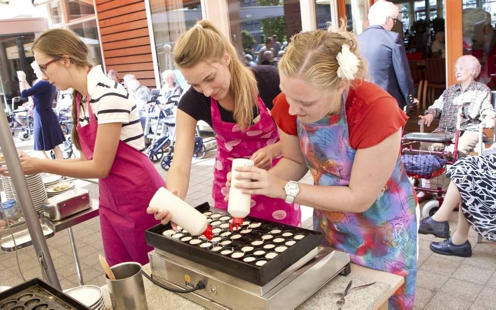 GOUDA. „Het wordt steeds belangrijker om de kern van de Bijbelse boodschap op een positieve manier uit te dragen”, zegt Driestarbestuurder Rens Rottier. Foto: Pabo-studenten van de Driestar bakken poffertjes voor ouderen tijdens een actiedag met vrijwilli