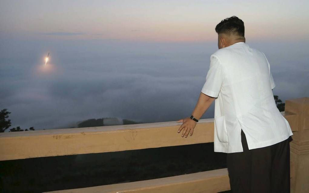 Niet gedateerde foto van de Noord-Koreaanse dictator Kim Jong Un, kijkend naar een zonsondergang.  beeld EPA