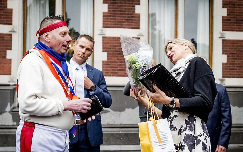 De koningin neemt bloemen in ontvangst bij het Academiegebouw in Utrecht. beeld ANP