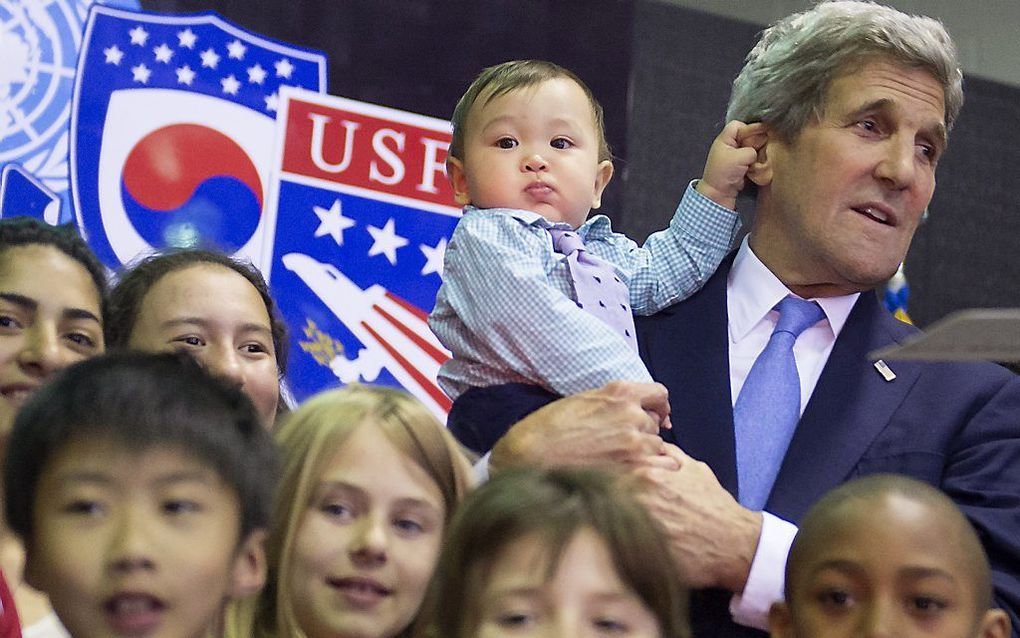 De Amerikaanse minister van Buitenlandse Zaken John Kerry krijgt een draai om de oren van de acht maanden jonge Andrew Belz als hij in de Zuid-Koreaanse hoofdstad Seoul poseert met kinderen van ambassadepersoneel en militairen uit de VS. beeld AFP