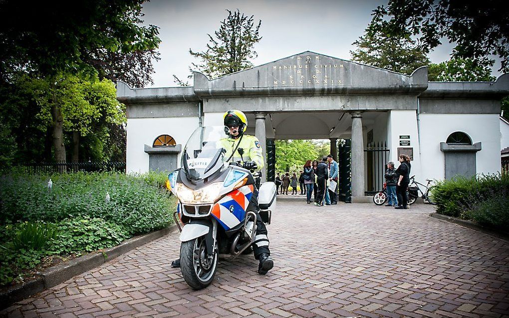 Een agent bewaakt de entree van de Algemene Begraafplaats Westerweg in Alkmaar waar een dansvoorstelling wordt gehouden. Beeld ANP