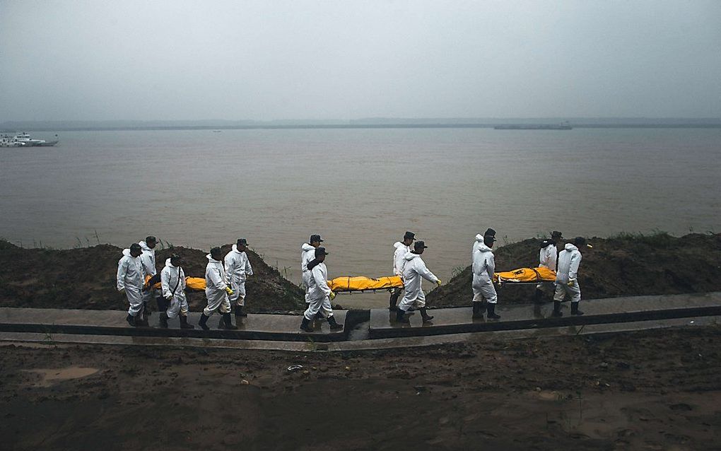 Reddingswerkers halen doden uit de zee. Beeld AFP