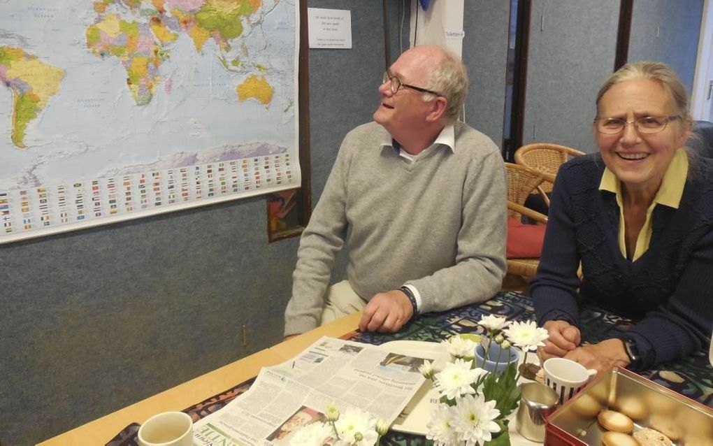 Initiatiefnemers Joop van Herwijnen (l.) en Aleid Groothoff in de huiskamer van het nieuwe Wereldhuis. Op de wereldkaart geven bezoekers hun land van herkomst aan. beeld Steven van den Berg