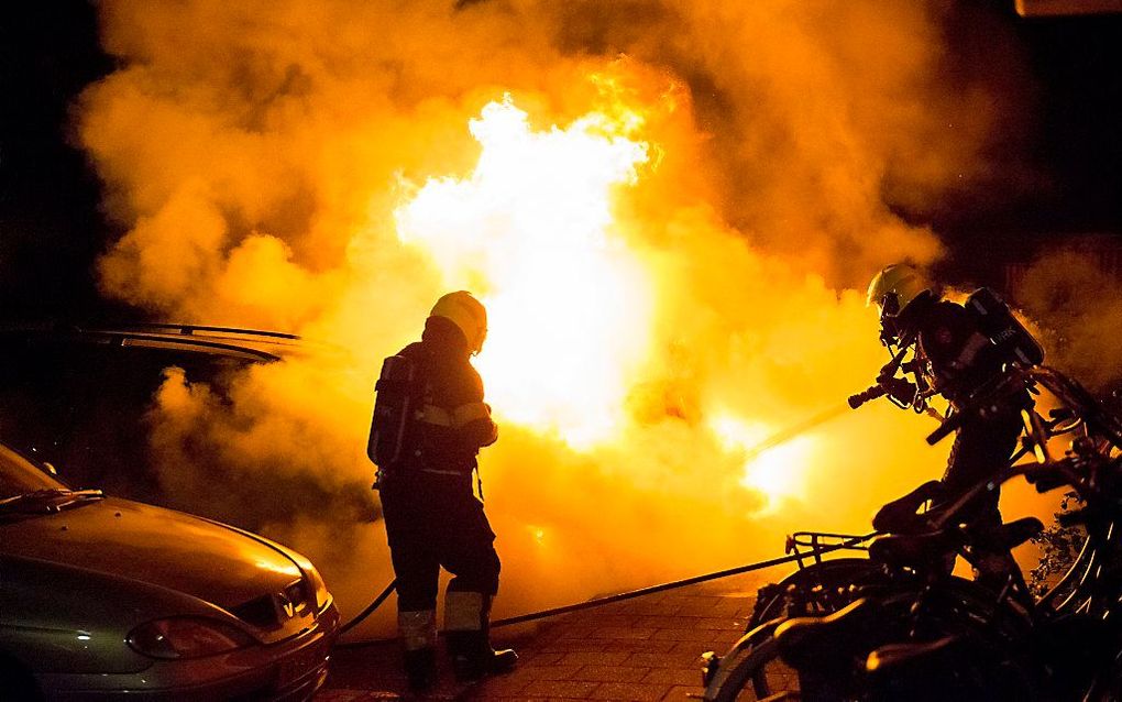 De brandweer blust de auto van de Haarlemse burgemeester Schneiders. Beeld ANP