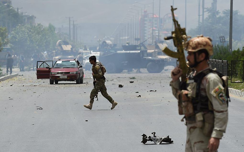 Veiligheidstroepen maandag na de aanslag op het parlement in Kabul. Beeld AFP