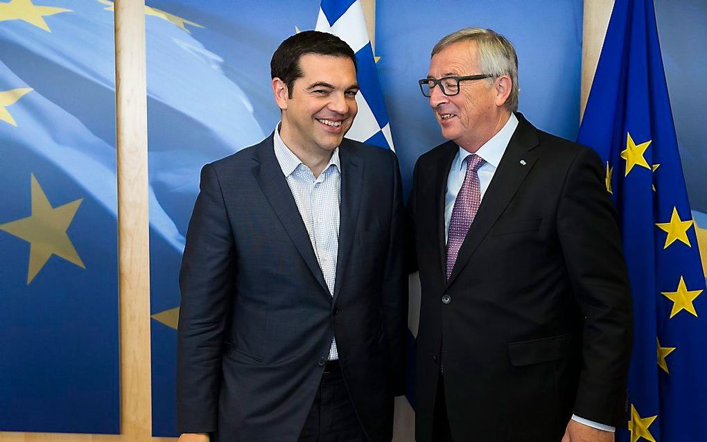 De Griekse premier Alexis Tsipras woensdag met voorzitter Jean-Claude Juncker van de Europese Commissie voor overleg in Brussel voor de Europese vlag. Beeld EPA