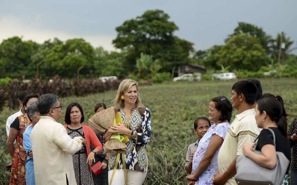 SILANG. De schuchtere Melissa Garcia (r.) en haar man gaven de koningin uitleg over de uitbouw van hun bedrijf. beeld AFP