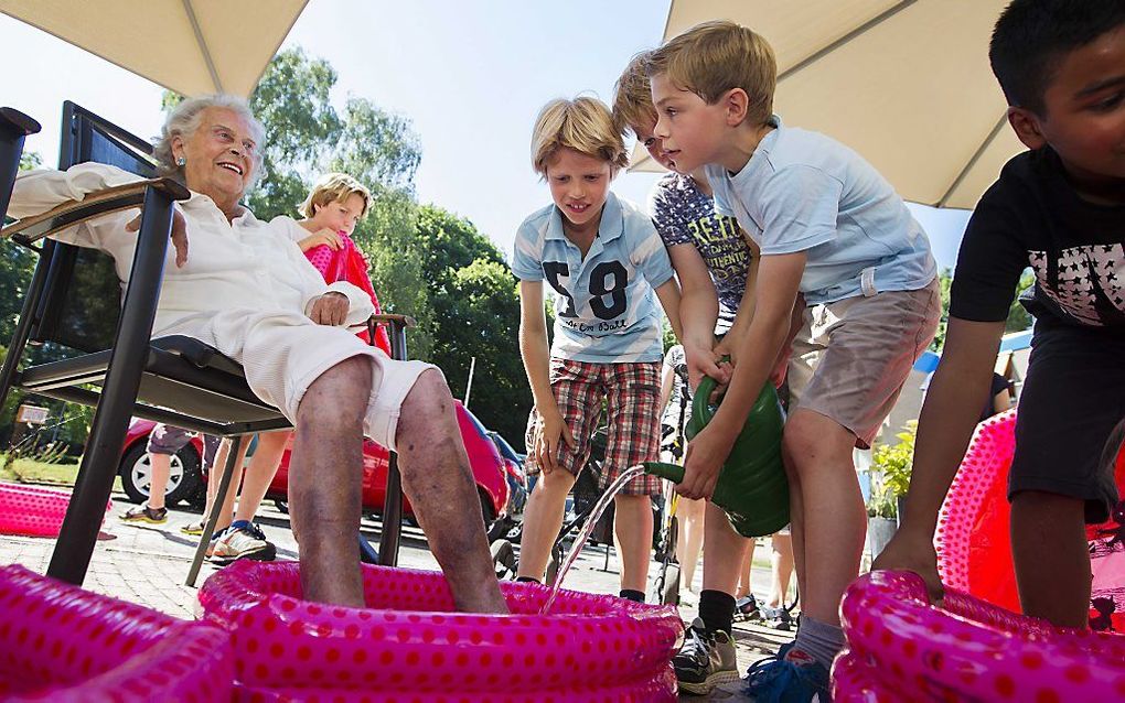 Leerlingen van de Kerckeboschschool delen voetenbadjes uit aan bewoners van verzorgingshuis Spathodea in Zeist. beeld ANP