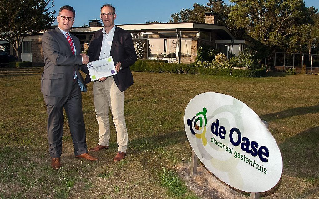 Pro Life-manager W. van Rossum overhandigde dinsdagavond aan de coördinator van het diaconaal gastenhuis de Oase in Ouddorp, Aart van Wolfswinkel (r.), het Keurmerk Christelijke Zorg. Het huis is een initiatief van diverse reformatorisch kerken.  beeld Ha