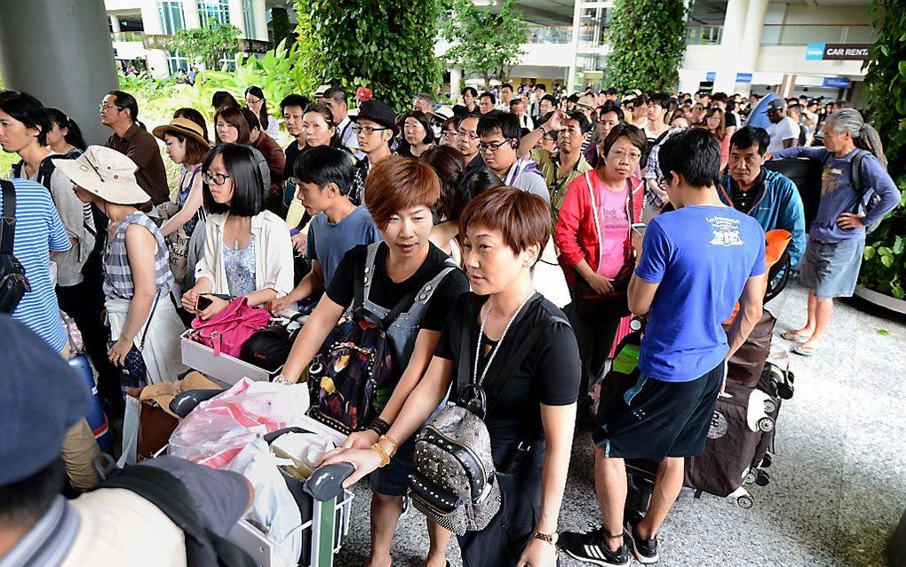 Passagiers in de rij op Ngurah Rai airport, Bali. beeld AFP