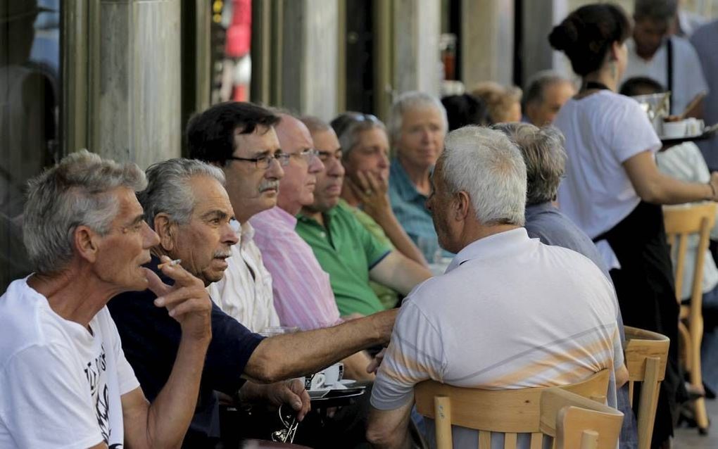 Griekse ouderen bespreken in Athene de situatie in hun land. beeld EPA