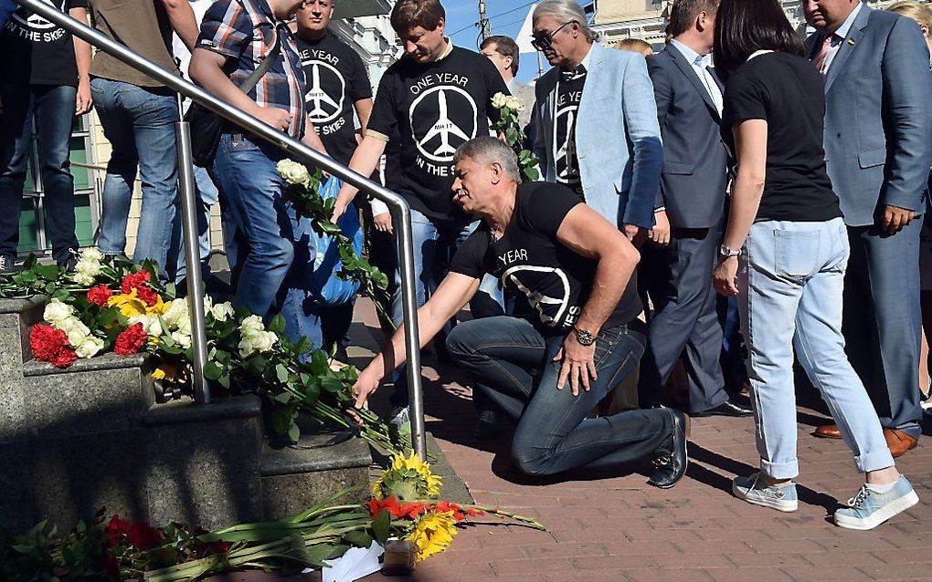 Oekraïners leggen bloemen bij de Nederlandse ambassade. beeld EPA