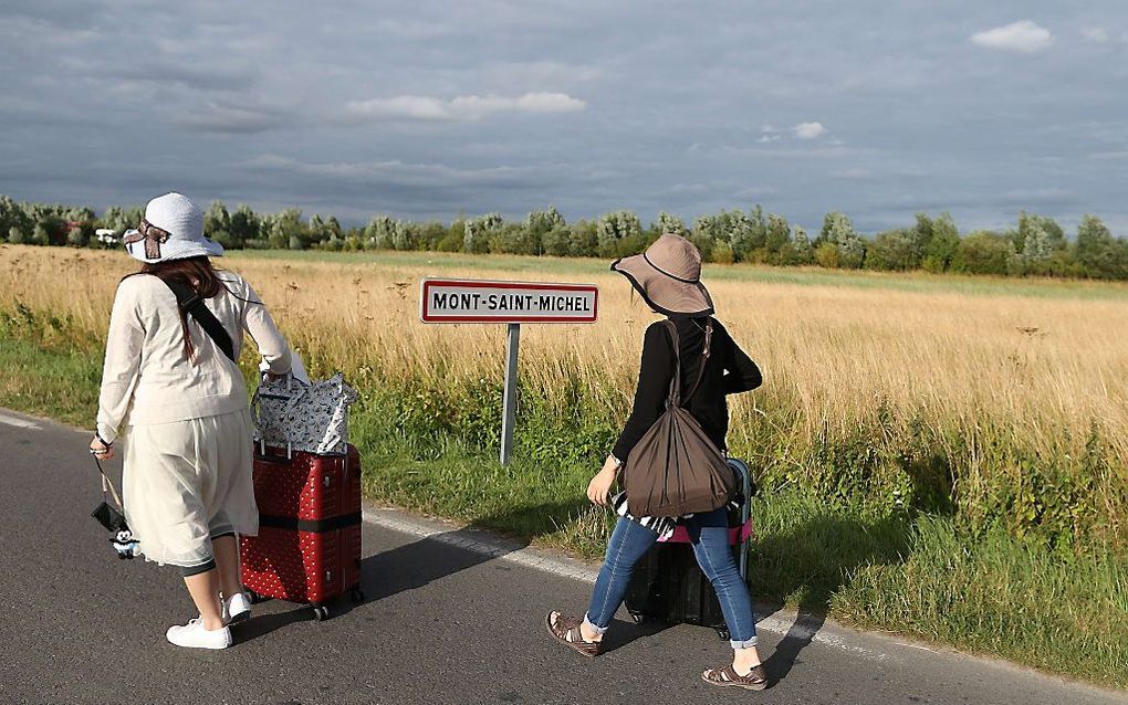 Ze kunnen verder als ze gaan lopen. Franse boeren dwongen maandag toeristen die een bezoek wilden brengen aan het schiereiland Mont Saint-Michel hun bus te verlaten. De boeren voerden actie voor hogere melk- en vleesprijzen. beeld AFP