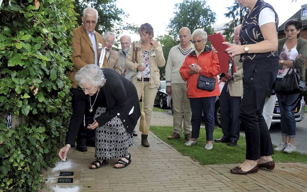 Maud Dahme-Peper legde gisteren een kiezelsteentje op de herdenkingsstenen in Amersfoort ter nagedachtenis aan haar familieleden die zijn vermoord in vernietigingskamp Sobibor. beeld Saskia Berdenis van Berlekom