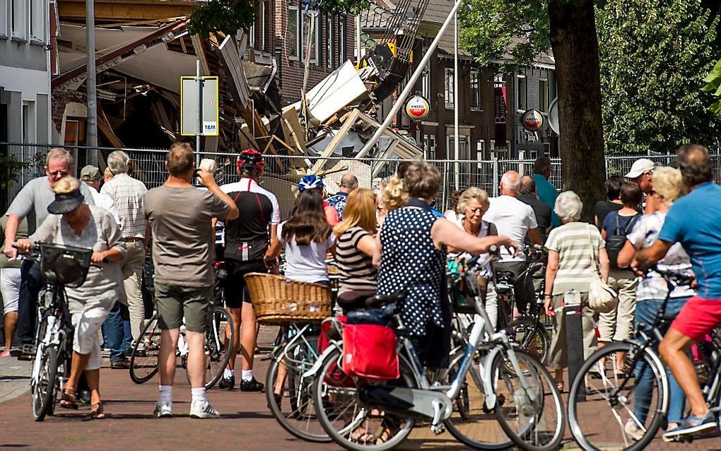 Belangstellenden kijken naar de enorme ravage. Beeld ANP