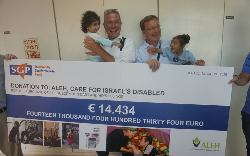 De SGP-parlementariërs Dijkgraaf (l.) en Van Dijk overhandigden donderdag een cheque aan gehandicapteninstelling Alev Negev. beeld RD