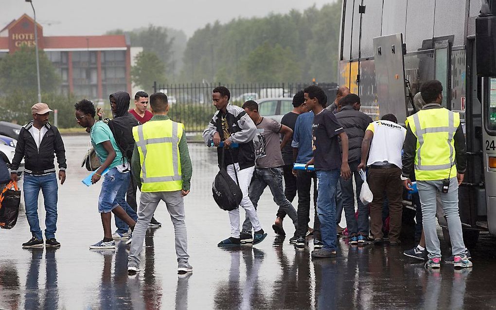 Een groep asielzoekers komt aan bij de Zeelandhallen in Goes. Beeld ANP