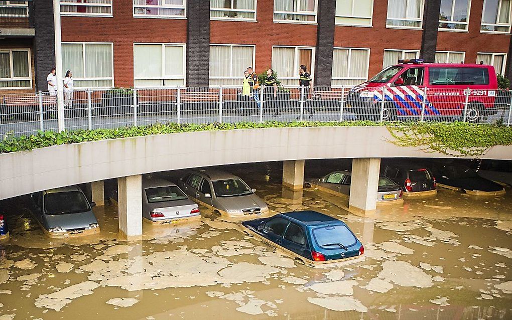 Een parkeergarage aan de Irene Vorrinkstraat in Nijmegen is in de nacht van zondag op maandag onder water gelopen nadat een dam van een naastgelegen vijver doorbrak. Men schat dat het ongeveer om 100 auto's gaat. Beeld ANP