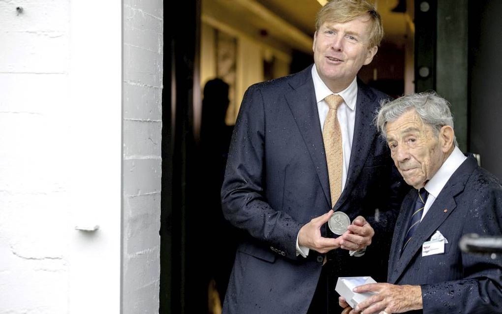 NOORDWIJK AAN ZEE. Koning Willem-Alexander en Engelandvaarder E. A. Jonker (95) in de deuropening van de bunker waarin het Museum Engelandvaarders is gevestigd. Na de opening van het museum overhandigde Jonker de koning een herdenkingsmunt met een uitspra