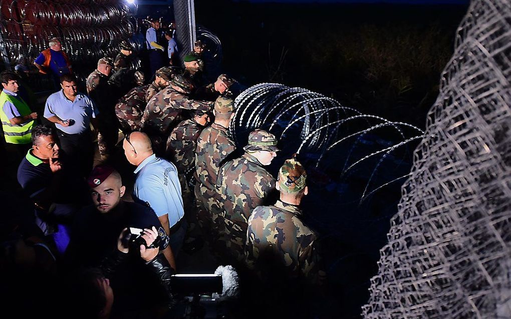 Hongaarse militairen sluiten maandag het laatste deel van de grens met Servië. Beeld AFP