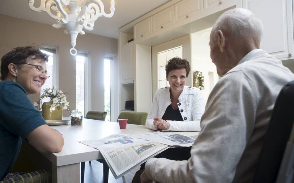 Coördinator Lucy den Ouden (m.) en vrijwilliger Tineke Kamphuis in gesprek met een bewoner van hospice De Olijftak in Ede.  beeld Herman Stöver