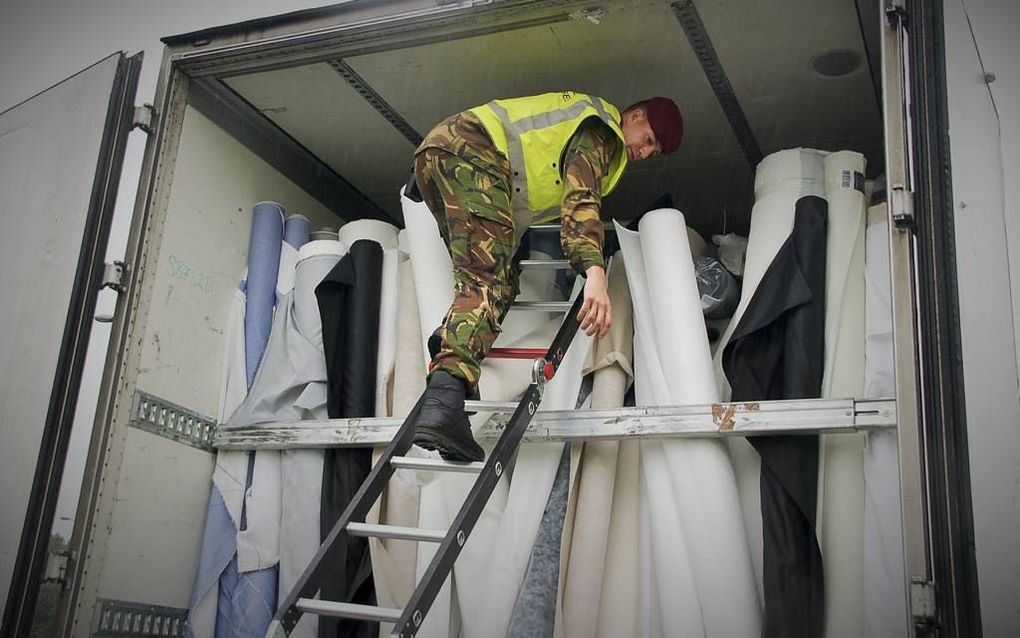 Een rode baret klimt in een truck. beeld Gerard ten Voorde