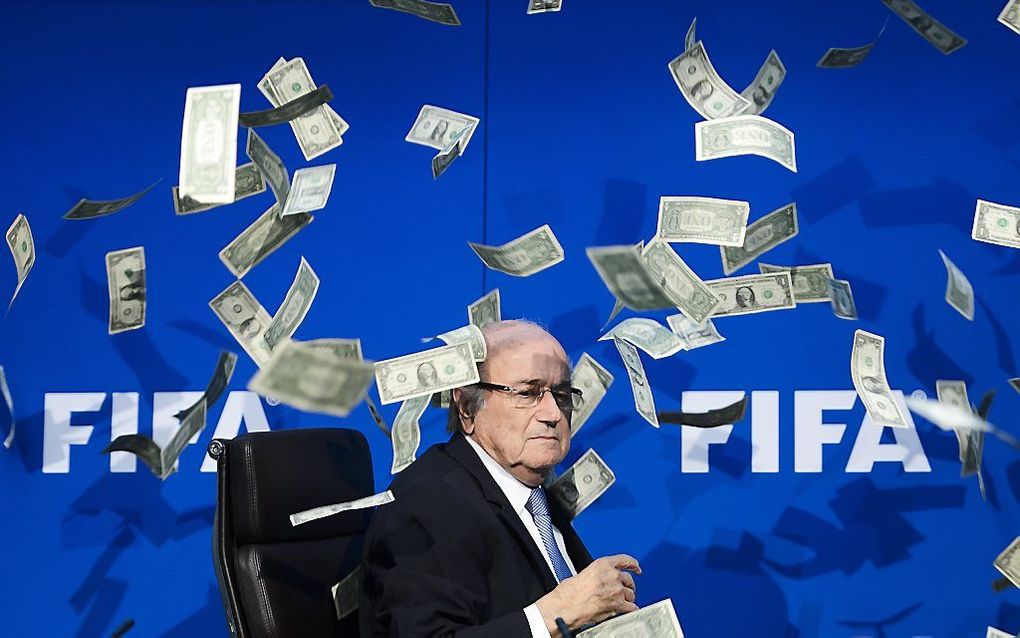 Blatter tijdens een persconferentie eerder dit jaar waarop hij wordt bestrooid met valse dollarbiljetten. beeld AFP