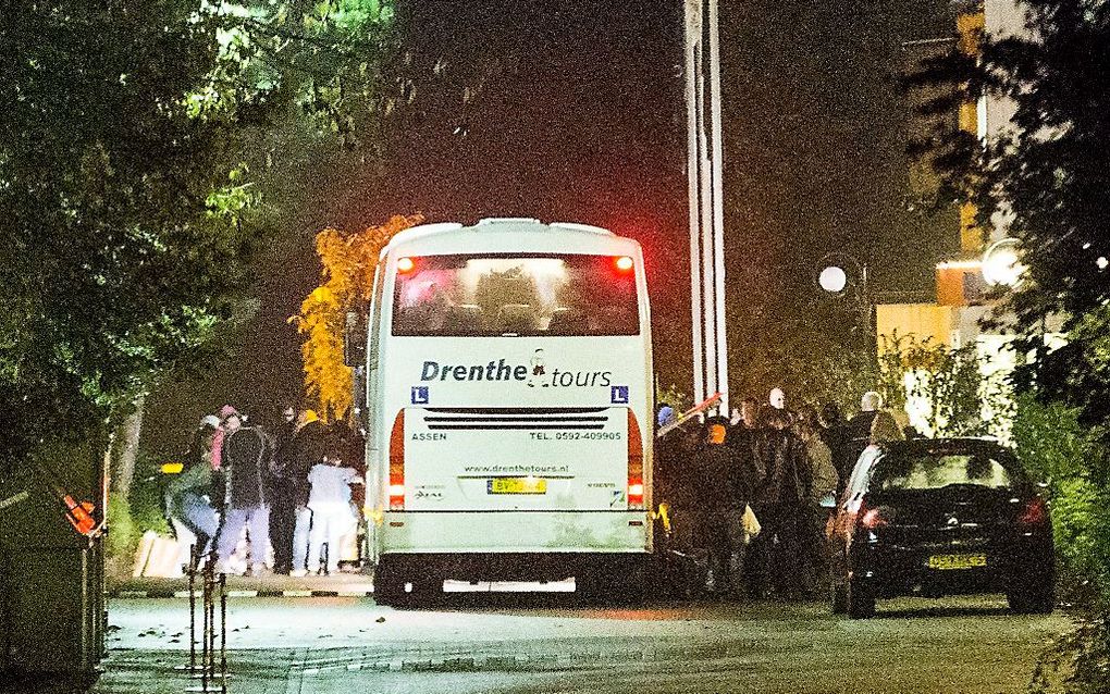 In het Drentse dorp Oranje arriveren twee bussen met vluchtelingen. Boze dorpsbewoners hadden eerder op de avond de weg afgezet met auto's, om te voorkomen dat de vluchtelingen zouden arriveren. beeld ANP