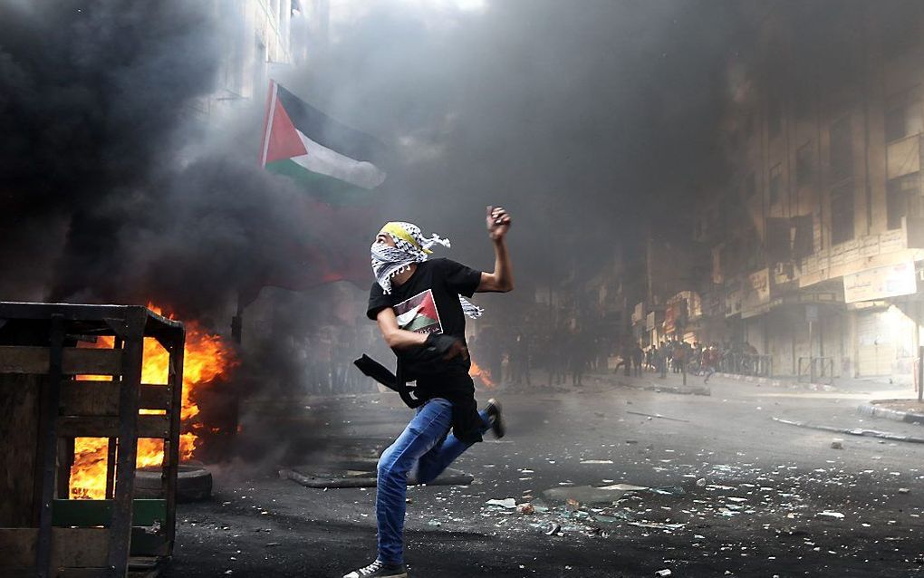 HEBRON. Een Palestijn gooit stenen naar Israëlische ordetroepen in Hebron. beeld AFP